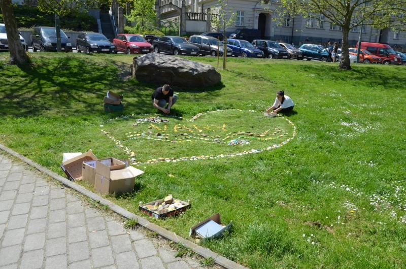 Skládání srdce z darovaných kamínků na trávníku náměstí Dr. Milady Horákové