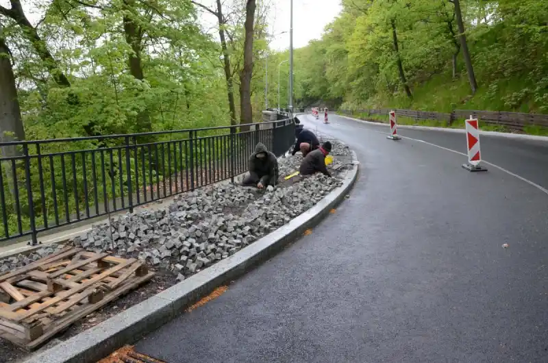 Dlaždiči pokládají poslední úsek chodníku