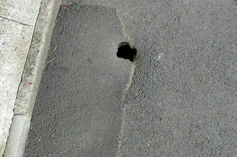 Propadlý asfalt s dírou 