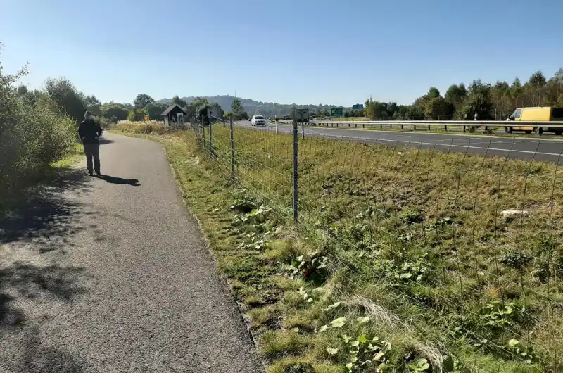 Foto z místa, kde je jasně vidět, že místo je odděleno od silnice pouze drátem.