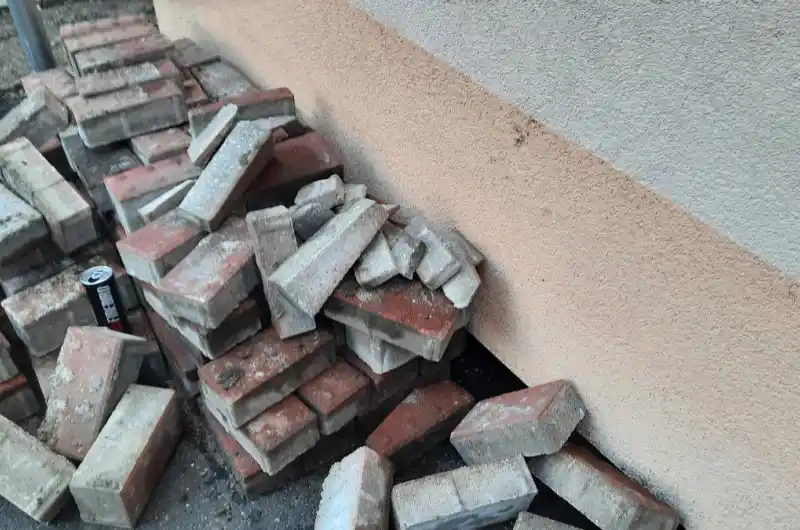 skladování vytrhané dlažby opřeno o fasádu domu