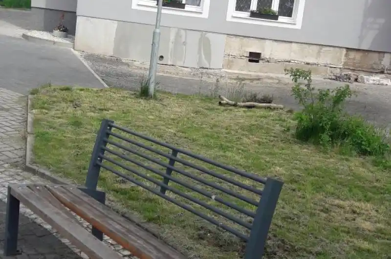 poškozená lavička u domu č. p. 10