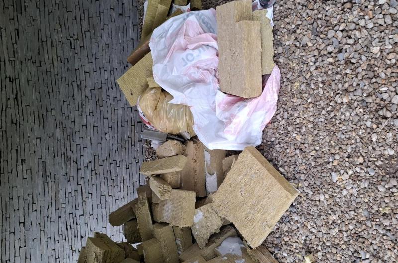 rozbitá koloběžka a plechovky v zateplovacích deskách