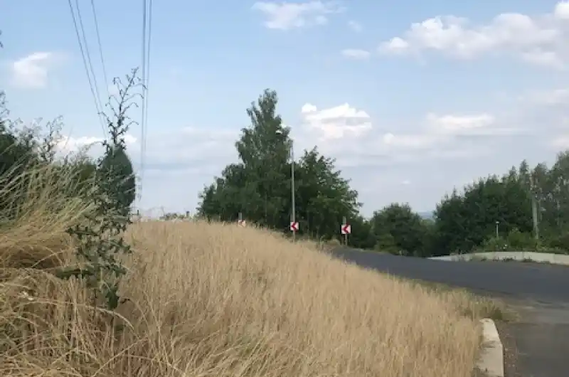 výjezd od ubytovny na silnici Teplárenská je nepřehledný kvůli vysoké trávě