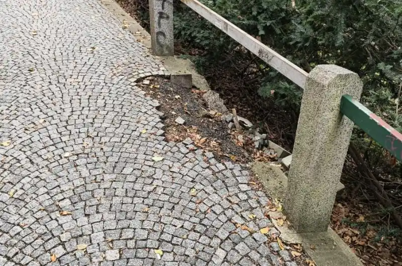 Díra v chodníku směřující do svahu